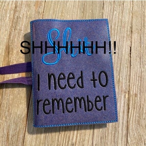 May include: A purple glitter notebook with a blue embroidered saying "Shhhhiiiiit! I need to remember".