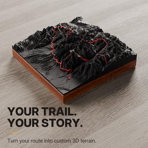 May include: A square 3D topographic terrain model featuring black mountains with a highlighted red trail path, set on a wooden base. Text reads: YOUR TRAIL. YOUR STORY. Turn your route into custom 3D terrain. DESIGN YOURS. TOPO 3D LLC YOUR MEMORIES TO TOUCH.