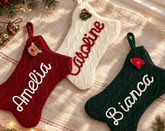 Puede incluir: Tres calcetines navideños de punto en rojo, blanco y verde oscuro. El calcetín rojo lleva el nombre Amelia, el blanco el nombre Caroline y el verde oscuro el nombre Bianca, todos en letras cursivas blancas sobre el frente.