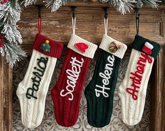 Puede incluir: Cuatro calcetines navideños personalizados colgados en fila. El primero es blanco con puño rojo y el nombre Patrick en verde, el segundo es rojo con puño blanco y el nombre Scarlett en blanco, el tercero es verde con puño blanco y el nombre Helena en blanco, y el cuarto es blanco con puño verde y el nombre Anthony en rojo.