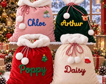 Puede incluir: Cuatro sacos de regalo navideños de terciopelo afelpado con ribete de piel sintética blanca y cierre de cordón. El saco rosa lleva el nombre Chloe, el verde Arthur, el rojo Poppy y el crema Daisy.