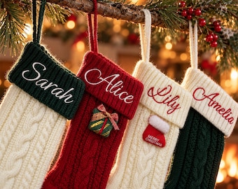 Puede incluir: Cuatro calcetines navideños de punto colgados de una rama. El primero es crema con puño verde oscuro bordado con Sarah. El segundo es rojo con puño rojo bordado con Alice y un adorno de regalo. El tercero es crema con puño crema bordado con Lily y un mini calcetín. El cuarto es verde oscuro con puño crema bordado con Amelia.