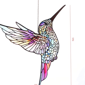 Puede incluir: Un atrapasoles de colibr&iacute; de vidriera, de 23 cm de altura, con un dise&ntilde;o de mosaico colorido. El p&aacute;jaro presenta un pico largo y oscuro y est&aacute; suspendido por una cadena. Las alas muestran tonos de morado, rosa y amarillo.