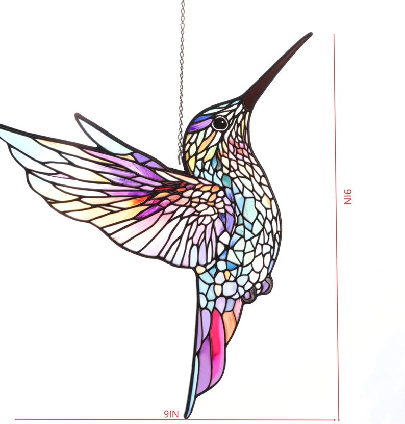 Puede incluir: Un atrapasoles de colibr&iacute; de vidriera, de 23 cm de altura, con un dise&ntilde;o de mosaico colorido. El p&aacute;jaro presenta un pico largo y oscuro y est&aacute; suspendido por una cadena. Las alas muestran tonos de morado, rosa y amarillo.
