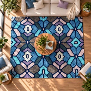 May include: A rectangular area rug featuring a repeating geometric pattern in shades of blue, light blue, lavender, cream, and dark gray. The rug has a textured, tufted surface with a symmetrical design composed of interconnected floral-like shapes.