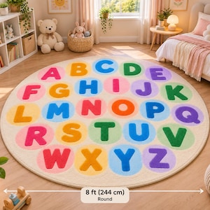 May include: A round, cream-colored area rug featuring the alphabet in colorful, bold letters. Each letter is centered within a soft-toned circular patch. The rug measures 8 feet in diameter, as indicated by the text label at the bottom of the image.