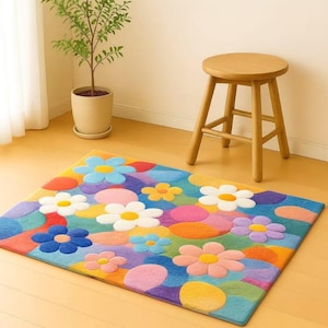 May include: A colorful rectangular rug with a floral pattern. The rug features large, stylized flowers in shades of blue, white, yellow, pink, and purple, set against a background of various colors. A wooden stool and potted plant are in the background.
