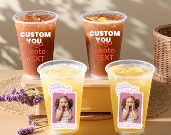 May include: Four clear plastic cups filled with iced beverages. Two cups contain a brown drink with the text "CUSTOM YOU logo photo TEXT". The other two cups have a yellow drink with a sticker that says "Let's party!" and a photo of a girl.