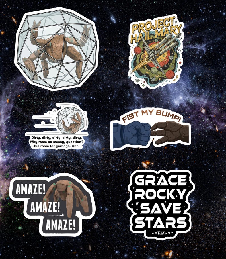 May include: A collection of white-bordered stickers with space-themed designs. The stickers feature illustrations of a space station, a creature in a cage, and text including "Project Hail Mary", "Fist My Bump!", and "Amaze!"