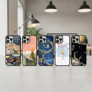 May include: Five phone cases with colorful illustrations from "The Little Prince." The cases feature various scenes, including a starry night, a boy on a cliff, and the text "Fall in Love." Each case has a black border.