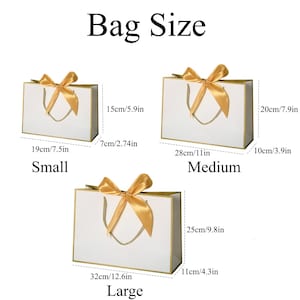 May include: A set of three ceramic mugs with a speckled, matte finish. The mugs are in shades of cream, light brown, and dark brown. Each mug has a simple, minimalist design and a rounded handle.
