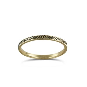 May include: A thin gold band ring with a black geometric pattern around the edge.