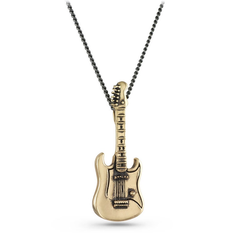 May include: A gold-colored electric guitar pendant necklace with a black chain. The guitar pendant has a detailed design with a pickguard and knobs.