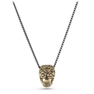 May include: A gold-coloured skull pendant necklace with a detailed floral design. The skull is suspended from a dark grey chain. The pendant features intricate carvings and a detailed skull face.