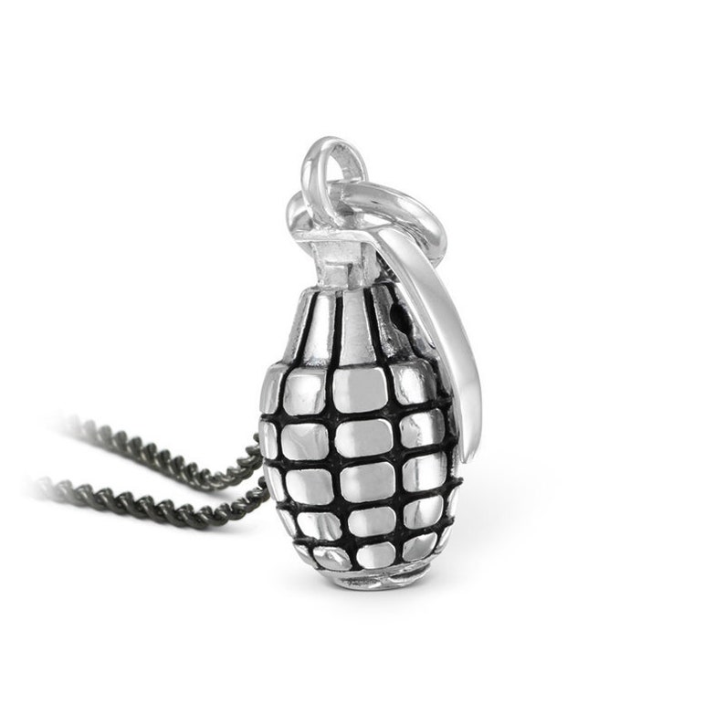May include: A silver grenade pendant necklace with a black chain. The pendant is detailed with a textured surface and a ring at the top for attaching to the chain.