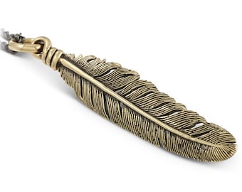 May include: A gold-toned feather pendant necklace. The feather is detailed with fine lines and has a textured surface.