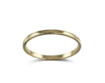 May include: A simple gold band ring.
