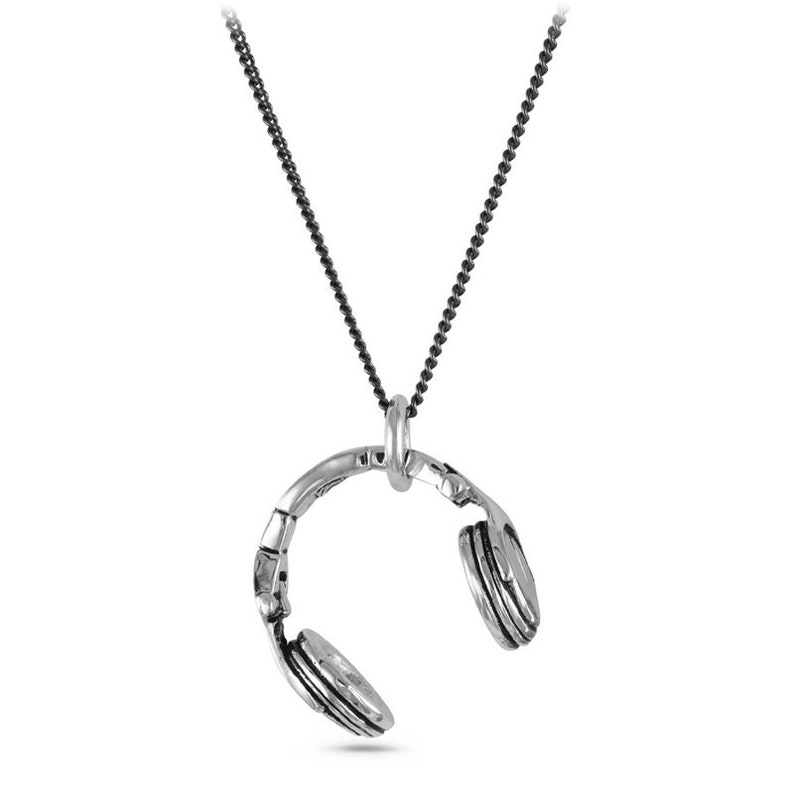 May include: A silver necklace with a pendant shaped like a pair of headphones. The chain is black and the pendant is detailed with a textured finish.