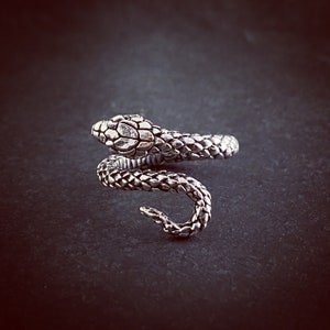 Op de afbeelding: Een zilveren slangenring met een getextureerd, schubbig ontwerp. De slang is opgerold en de kop kijkt naar voren.