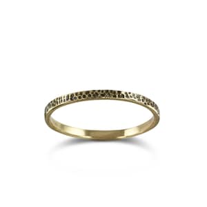 May include: A thin gold band ring with a hammered texture.
