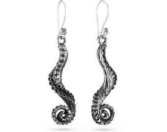 May include: Silver earrings shaped like an octopus tentacle, with a detailed textured design.