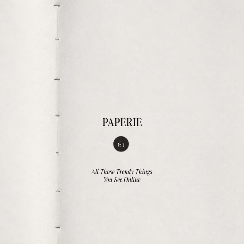 May include: A white page from a book with a stitched spine on the left. The text reads PAPERIE, followed by the number 61 inside a black circle, and the phrase All Those Trendy Things You See Online printed in black serif font on the page.