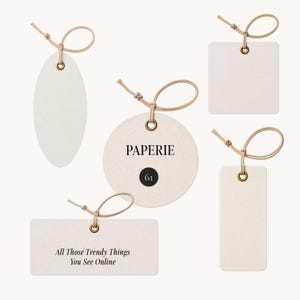 May include: Five off-white paper tags in oval, square, circular, and rectangular shapes, each with a metallic eyelet and a tan string loop. The circular tag features the text PAPERIE and 61, while the rectangular tag reads All Those Trendy Things You See Online.