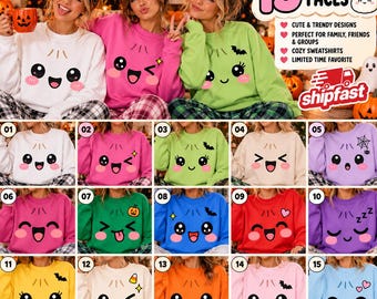 May include: A collection of fifteen crewneck sweatshirts in various colors, each featuring a unique kawaii-style dumpling face graphic. The designs include expressions like winking, sleeping, and smiling, accented with small icons like bats, hearts, and pumpkins.
