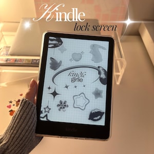 May include: A Kindle e-reader with a clear case displays a custom lock screen. The screen features various stickers, including butterflies, stars, and a bunny, with the text "Kindle Girlie". The word "Kindle" is printed at the bottom.