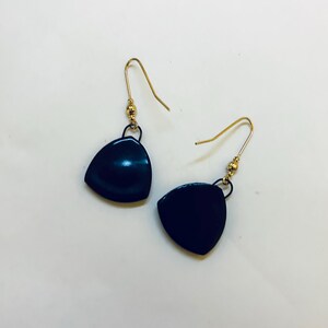 May include: A pair of dark blue, triangular earrings with gold-colored ear wires. The earrings have a smooth, glossy finish and a small gold bead detail near the ear wire.