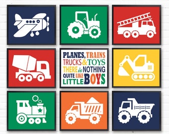 Puede incluir: Nueve impresiones enmarcadas con ilustraciones de varios vehículos, incluyendo un avión, un tractor, un camión de bomberos, una mezcladora de cemento, una excavadora, un tren, un camión volquete y una camioneta. Las impresiones están en una variedad de colores, incluyendo rojo, azul, verde, amarillo y naranja. El texto en una de las impresiones dice "PLANES, TRAINS, TRUCKS & TOYS THERE IS NOTHING QUITE LIKE LITTLE BOYS".
