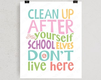 May include: A white poster with the text "CLEAN UP AFTER YOURSELF SCHOOL ELVES DON'T live here" in various bright colors. The poster is held by two black binder clips.