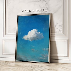 Puede incluir: Impresión artística enmarcada que presenta un cielo azul vibrante con una sola nube blanca y esponjosa. La obra de arte se muestra en un marco negro y se apoya contra una pared de mármol blanco. El texto "MARBLE WALLS" está en la parte superior.