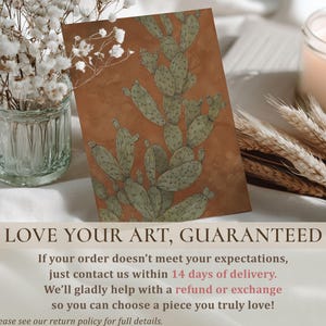 Vintage prickly pear cactus in green and terracotta, calm desert feel, presented as a wall art print on a styled tabletop with guarantee text.