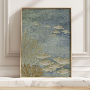 May include: A framed art print featuring an underwater scene with schools of fish and coral. The artwork has a blue and green background with gold-colored fish and coral. The frame is a light wood color.
