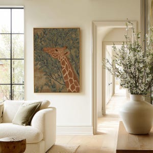 Vintage-style giraffe in green and brown framed by foliage, quiet and earthy mood, presented as a framed poster in an airy living room near an archway.