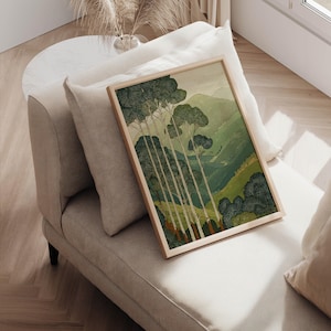 Tall trees against rolling green hills in a Japanese-inspired, tranquil wall art print, posed on a cushioned chair with sunlight nearby.