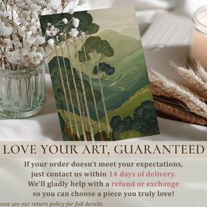 Tall trees and layered green mountains in a calm, vintage-style wall art print, styled on a tabletop with florals and a 14-day guarantee overlay.