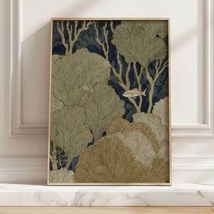 May include: A framed art print featuring an underwater scene with stylized coral and fish. The artwork uses a palette of muted gold, brown, and navy blue. The print is encased in a light-colored wooden frame, adding a touch of natural warmth.