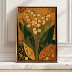 May include: A framed art print featuring a stylized illustration of lily of the valley flowers. The artwork has a warm color palette with shades of gold, green, and orange. The flowers are white, and the leaves are dark green.