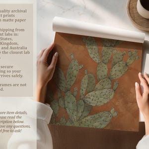Detailed prickly pear cactus illustration in sage and clay tones, calm vintage style, shown as an unrolled art print on a tabletop with info panel.