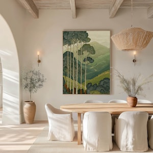 Vintage-style landscape of tall trees and layered hills in a serene poster, centered above a round dining table in a warm dining room.