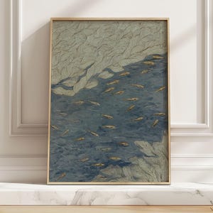 May include: A framed art print depicting fish in water, with a palette of blues, greens, and gold. Detailed line work creates a textured effect. The light wood frame complements the artwork. The print would suit a living room or bedroom, adding a touch of nature.