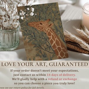 Soft green-and-brown giraffe foliage illustration, vintage naturalist style and peaceful mood, presented as a wall art print on a styled tabletop with florals and guarantee text.
