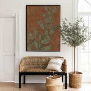 Desert prickly pear botanical in muted green and warm brown, calm earthy style, featured as a framed poster above a woven entryway bench.