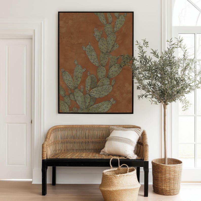 Desert prickly pear botanical in muted green and warm brown, calm earthy style, featured as a framed poster above a woven entryway bench.