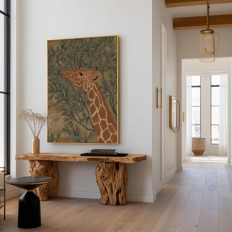 Botanical giraffe artwork in green and brown with fine linework, calm naturalist vibe, hung as a framed wall art print in a minimal hallway above a rustic console.