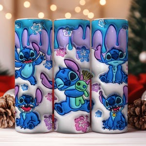 May include: Three cylindrical tumblers featuring the character Stitch from Lilo & Stitch. The tumblers have a white base with blue, purple, and pink accents. Stitch is depicted in various poses, surrounded by floral designs.