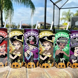 May include: Six Starbucks-themed tumblers featuring Disney princesses in Halloween witch costumes. Each tumbler has a different color scheme, including red, yellow, purple, green, and orange, with a pumpkin and witch hat design. The tumblers have white straws.
