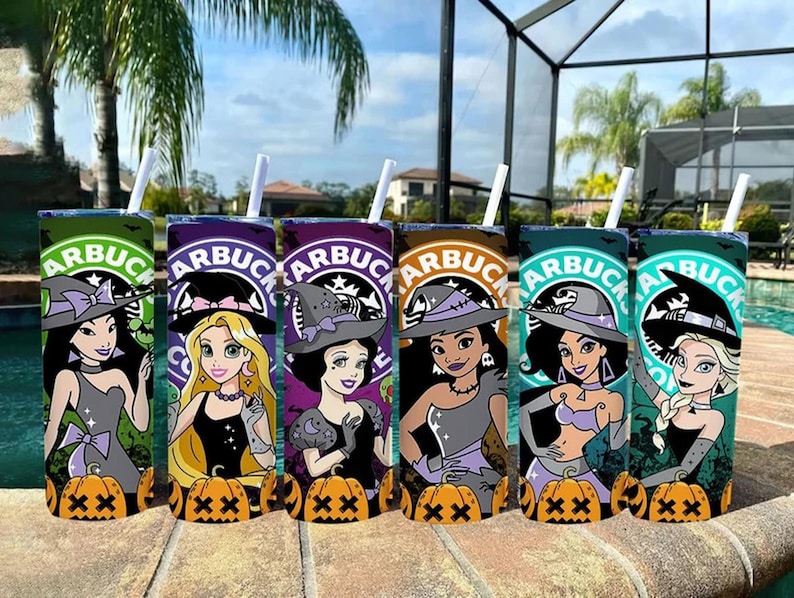 May include: Six colorful tumblers with white straws, featuring Disney princess illustrations in witch costumes. Each tumbler has a Starbucks logo and a pumpkin at the base. The tumblers are arranged on a stone surface near a pool.
